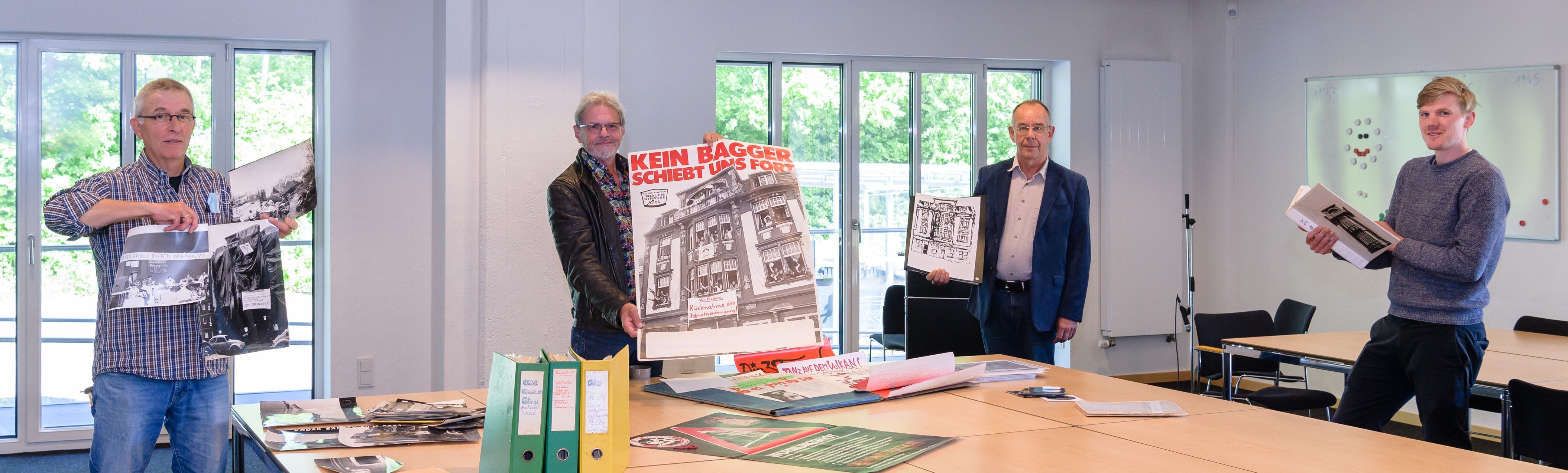 Vom Protest zum Archivgut (v.l.): Joachim Kämper, Bernd Uppena (ehemalige Haussprecher) und Dr. Joachim Hetscher (Kulturverein Frauenstraße) übergeben dem Stadtarchiv mit Dr. Philipp Erdmann einen umfangreichen Nachlass.  Foto: Presseamt Münster.