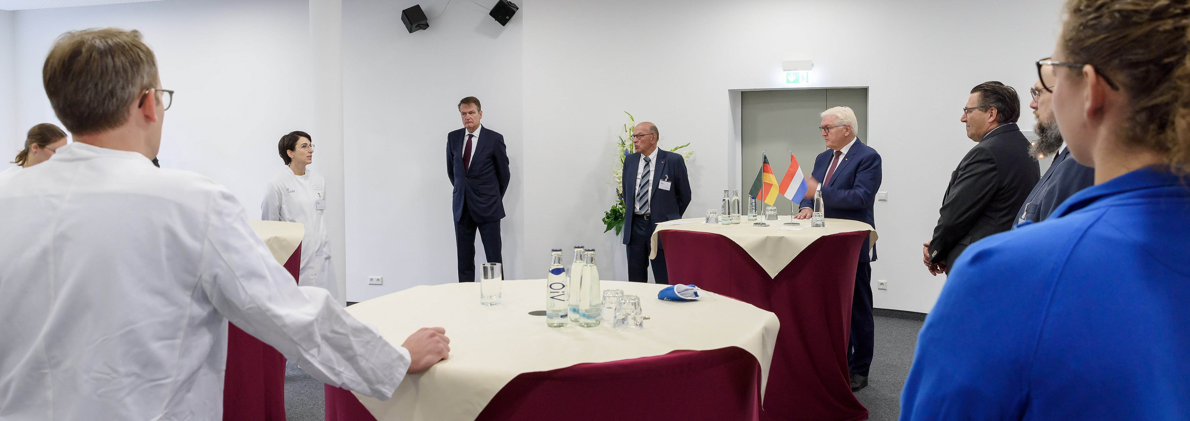 Bundespräsident Frank-Walter Steinmeier, Univ.-Prof. Hugo Van Aken und der niederländische Botschafter Wepke Kingma (Mitte, v.r.n.l.) lassen sich von Intensivmedizinern und Pflegekräften den Arbeitsalltag mit Covid-19-Patienten erläutern. (UKM/Schirdewahn)