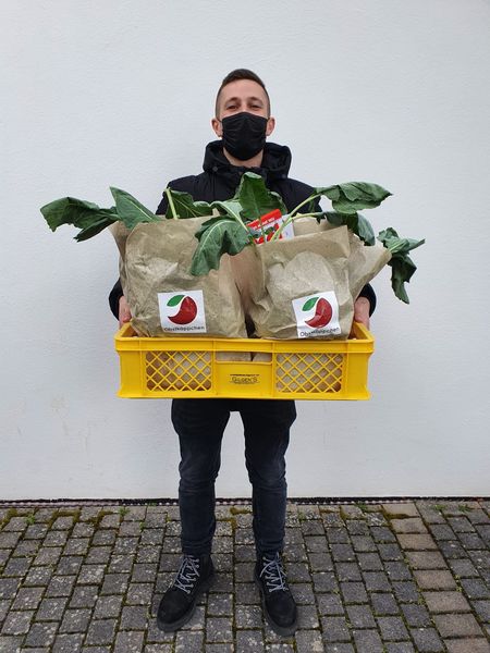 Ehrenamtlicher Helfer bei LichtBlick Seniorenhilfe e.V. mit einem Obstkäppchen