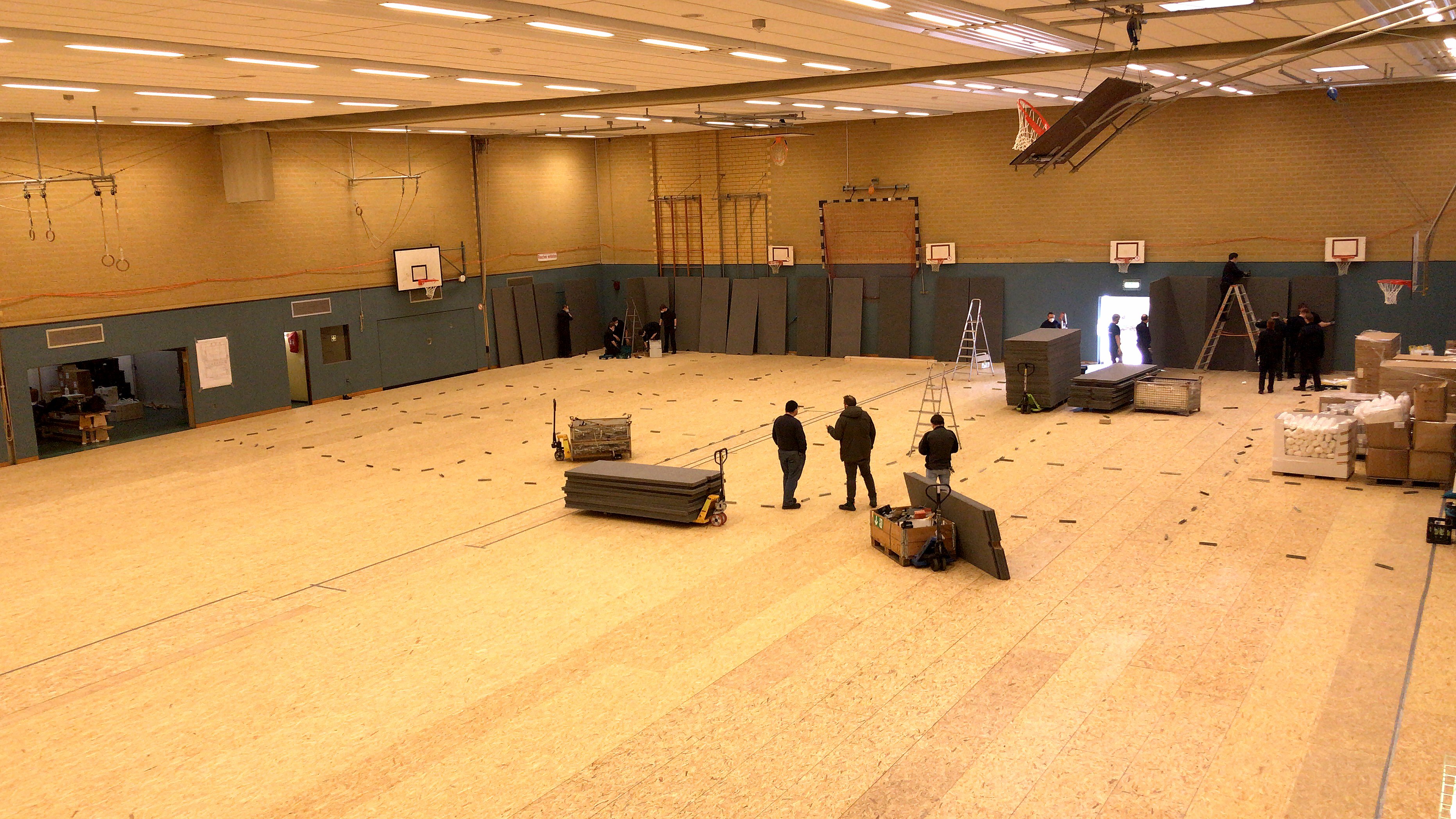 In vollem Gange sind bereits die Einrichtungsarbeiten in der Dreifachsporthalle an der Stadthalle Hiltrup. Der Boden wurde von Donnerstag zu Freitag verlegt. Foto: Amt für Kommunikation, Stadt Münster.