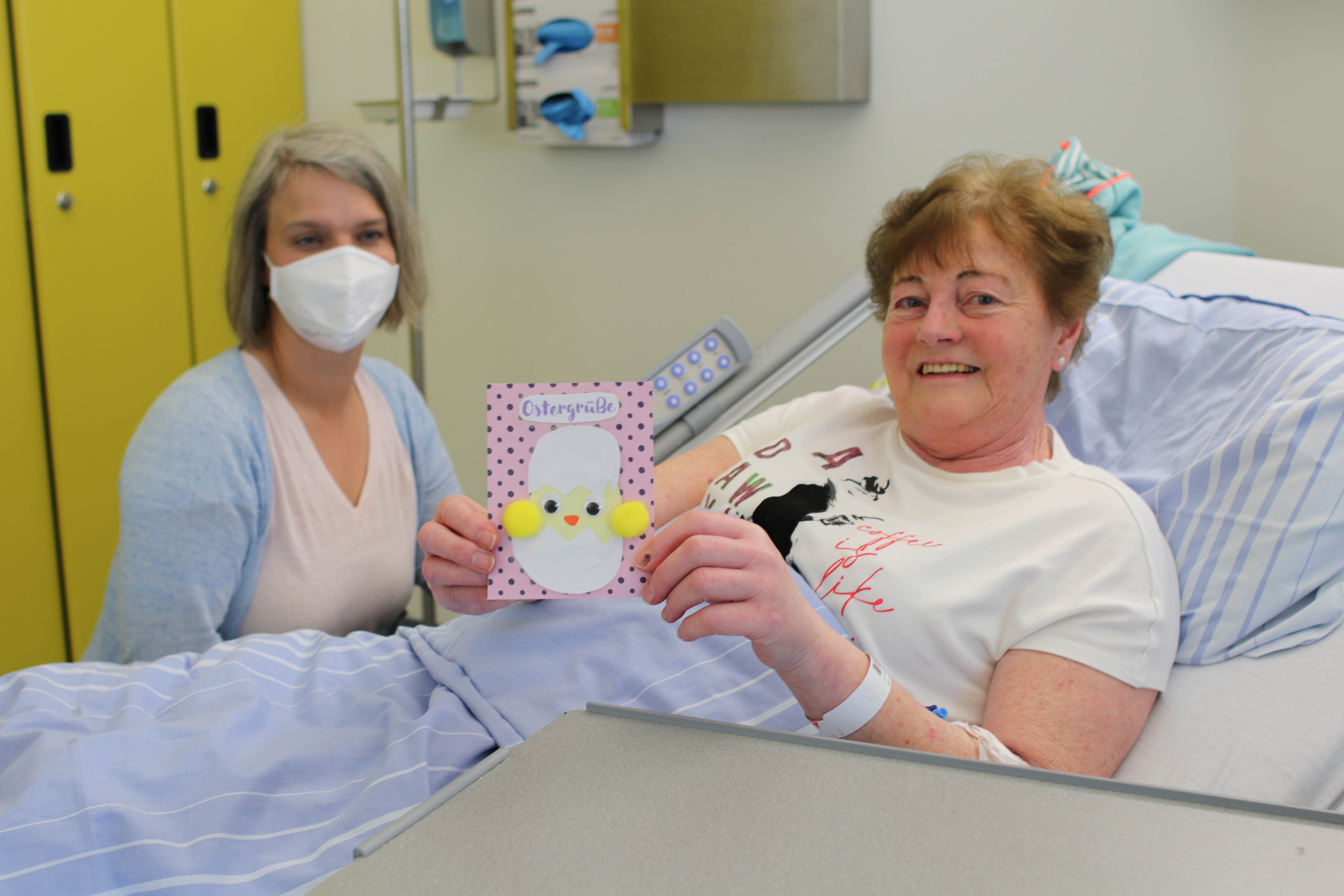 Toll gestaltete Karten mit herzlichen Ostergrüßen durfte heute u.a. Marion Schäferhoff (l.) von der Angehörigenberatung des UKM auf die Stationen bringen – zur sichtlichen Freude dieser Patientin. / UKM